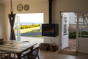 a dining room with a wooden table and a tv at Seafront house with a view in Kleinmond