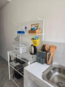 a kitchen counter with a dish rack next to a sink at MAXi MaMa Room in Bangkok