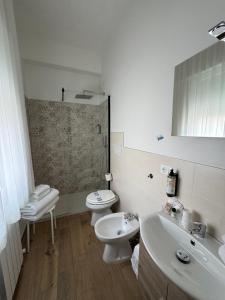a bathroom with two toilets and a sink and a mirror at Hotel Ammare in Sottomarina