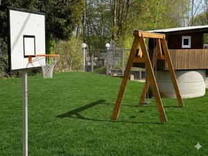 an outdoor basketball hoop with a net on the grass at W-Apartments - Spacious Parking, EV-Station & Private Outdoor Area with Playground in Offenburg