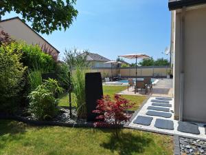a backyard with a garden and a patio at Le Garage & Spa Gold in Gondreville