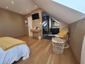 a bedroom with a bed and a desk in a room at Le Garage & Spa Gold in Gondreville