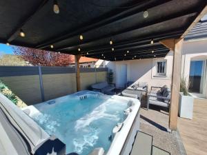 a hot tub on the patio of a house at Le Garage & Spa Gold in Gondreville