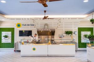 a chef preparing food in a restaurant kitchen at Club del Sole Marina Family Resort in Punta Marina +97 photos