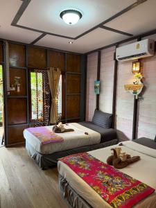 a room with two beds and a couch in it at P P Garden Home Bungalow in Phi Phi Islands