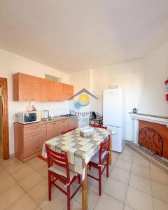 a kitchen with a table and chairs and a refrigerator at Sardegna 20 in San Teodoro +11 photos