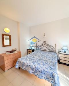 a bedroom with a bed with a blue and white bedspread at Sardegna 20 in San Teodoro