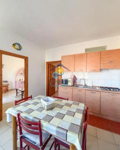 a kitchen with a table and chairs and a kitchen with a counter at Sardegna 20 in San Teodoro