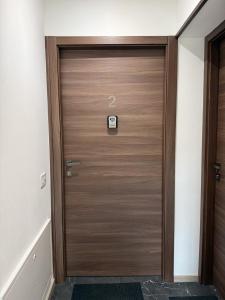 a wooden door in a hallway with a sign on it at Alla Rupe 8 - bilocale con vista sulle Alpi in Grosotto
