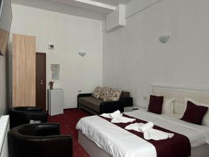 ein Hotelzimmer mit zwei Betten und einer Couch in der Unterkunft Hotel Ostrov in Călimăneşti + 29 Fotos