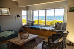 a living room with a couch and a large window at Seafront house with a view in Kleinmond