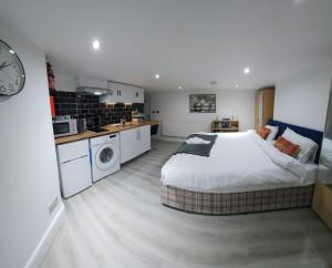 a bedroom with a large bed and a kitchen at Oxford Private Flat One in Oxford