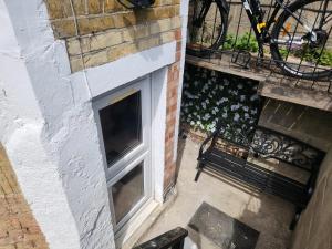 a window on the side of a building with a bench at Oxford Private Flat One in Oxford