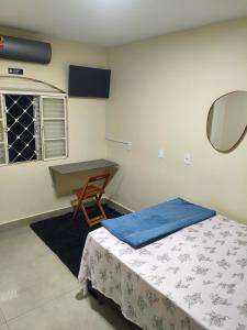 a bedroom with a bed and a table and a chair at Casa Marco in Anápolis