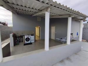 a house with a washing machine under a roof at Casa Marco in Anápolis
