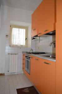a kitchen with orange cabinets and a sink at Borgo nel Centro in Ronciglione