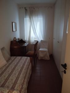 a bedroom with a bed and a desk and a window at Borgo nel Centro in Ronciglione