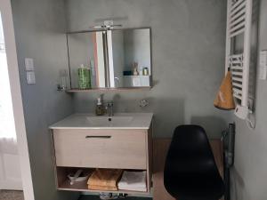a bathroom with a sink and a black chair at Studio aux portes de Parthenay in Châtillon-sur-Thouet