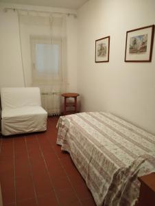 a bedroom with a bed and a chair and a window at Borgo nel Centro in Ronciglione