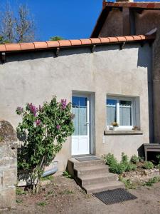a house with a white door and two windows at Studio aux portes de Parthenay in Châtillon-sur-Thouet