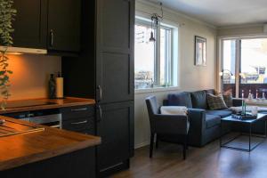 a kitchen and living room with a couch and a table at Stølstunets sentrumsglimt in Beitostøl