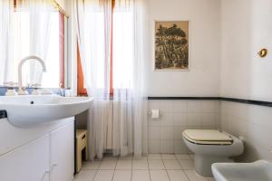 a white bathroom with a sink and a toilet at Podere Magnolia in Pisa +32 photos