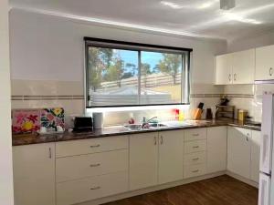 a kitchen with a sink and a window in it at Oak Hill Cottage - Chirnside Park in Wonga Park