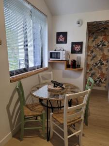 a dining room with a table and chairs and a microwave at Le petit chalet in Mazaye