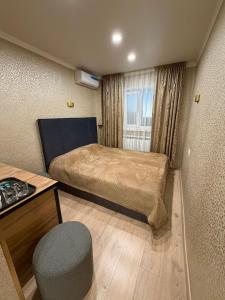 a small room with two beds and a chair at Sky 28 in Almaty