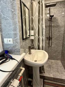 a bathroom with a white sink and a shower at Sky 28 in Almaty +34 photos