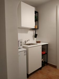 a white kitchen with a sink and a microwave at Bed and Breakfast In Piazza Orazio in Venosa +17 photos