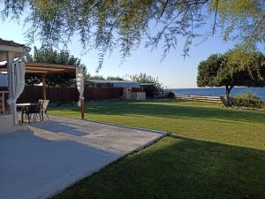 a backyard with a table and chairs and the ocean at Cedrus-Seafront Ionian Stay in Agios Georgios
