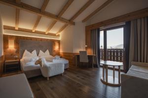 a hotel room with a bed and a balcony at Hotel Emmy - five elements in Völs am Schlern +213 photos