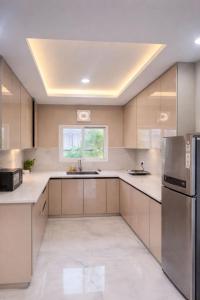 a large kitchen with white counters and stainless steel appliances at Shiv kashi farm luxury 3bhk with big pool in Noida
