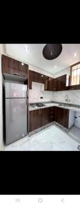 a kitchen with marble counter tops and a refrigerator at Appartements ELKHAIR in Tahannout