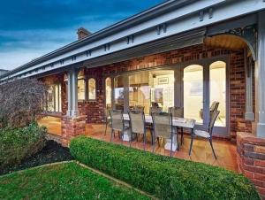 a patio with chairs and a table on a house at Oak Hill House - Chirnside Park in Wonga Park