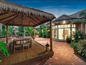 a patio with a table and chairs and a building at Oak Hill House - Chirnside Park in Wonga Park