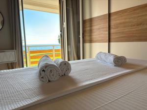 a bed with towels on it with a view of the ocean at Cedrus-Seafront Ionian Stay in Agios Georgios