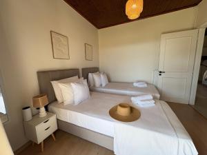 two beds in a bedroom with a hat on top at Cedrus-Seafront Ionian Stay in Agios Georgios