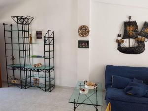a living room with a blue couch and a table at Airy and cosy summer flat in Siviri