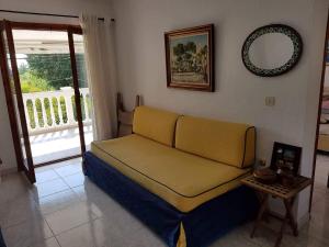 a couch in a living room with a mirror at Airy and cosy summer flat in Siviri +15 photos