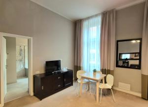 a living room with a table and a television at Hirscher Loft in Braşov