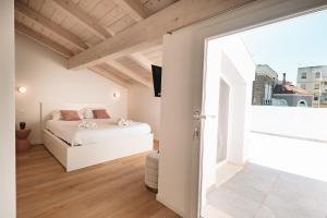 a bedroom with a white bed and a large window at City Boutique in Porto Torres