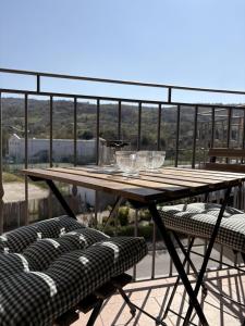 a wooden table with glasses on top of a balcony at Civico 107 in Capolona
