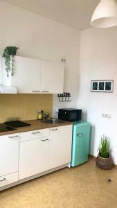a kitchen with white cabinets and a blue refrigerator at Römerburg Apartments Burgstraße in Boppard