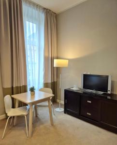 a room with a table and a tv and a table and chairs at Hirscher Loft in Braşov