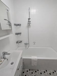 a white bathroom with a tub and a sink at Härtsfeldwohnungen in Neresheim +7 photos