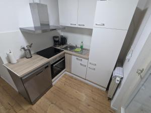a small kitchen with white cabinets and a sink at Härtsfeldwohnungen in Neresheim