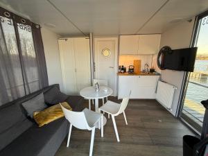 a living room with a couch and a table and a kitchen at Hausboot Luft & Liebe in Halle an der Saale +8 photos