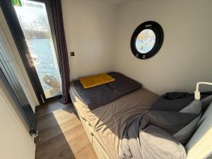 a small bedroom with a bed and a window at Hausboot Luft & Liebe in Halle an der Saale